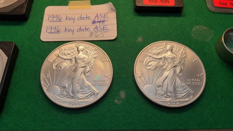 A 1996 American Silver Eagle next to a 2012 Silver Eagle on green felt