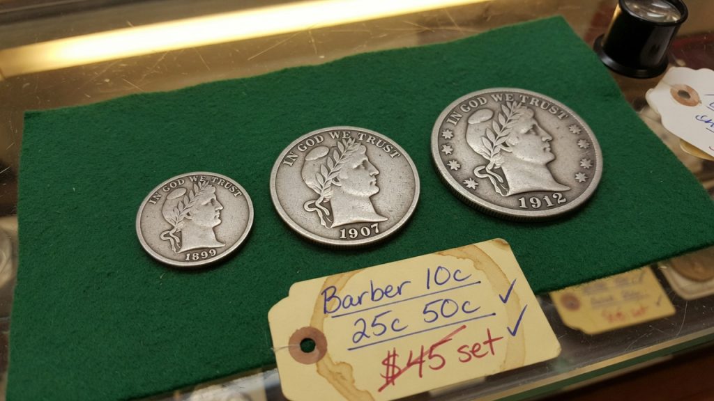 An 1899 Barber dime, 1907 quarter, and 1912 half dollar on green felt