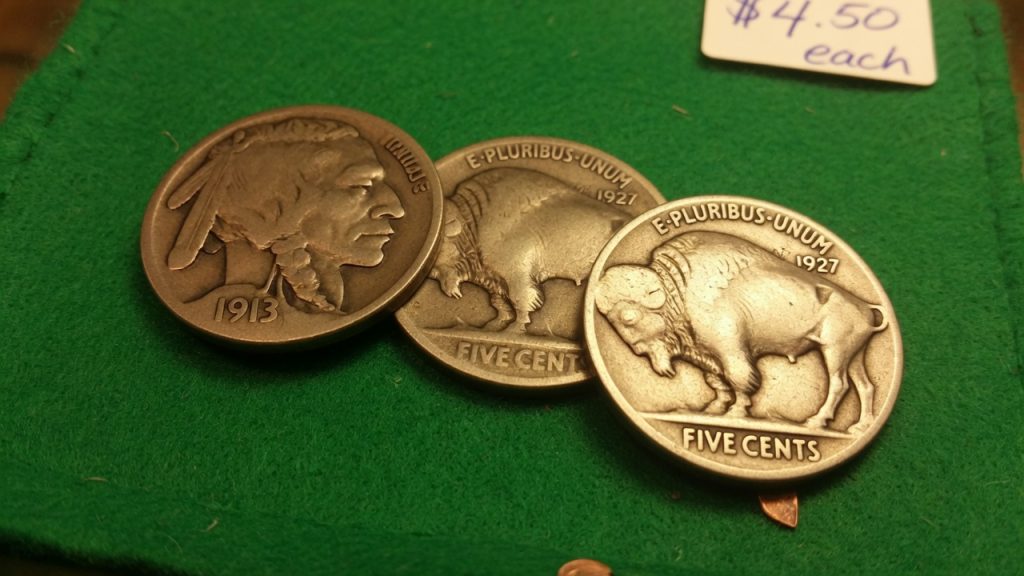 Three Buffalo nickels on green felt, a 1913 Indian-head obverse and two 1927 bison reverses