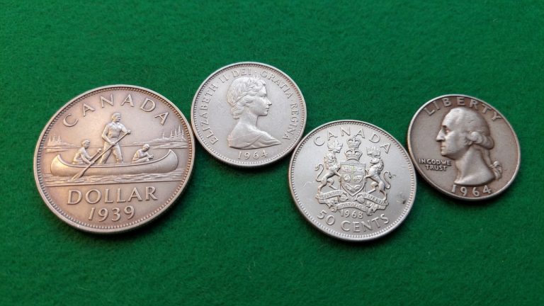 A 1939 Canadian voyageur dollar, a 1964 quarter, a 1968 50 cents, and a US 1964 quarter