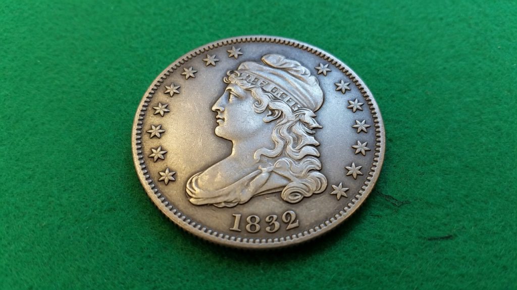 A Capped Bust United States half dollar on green felt