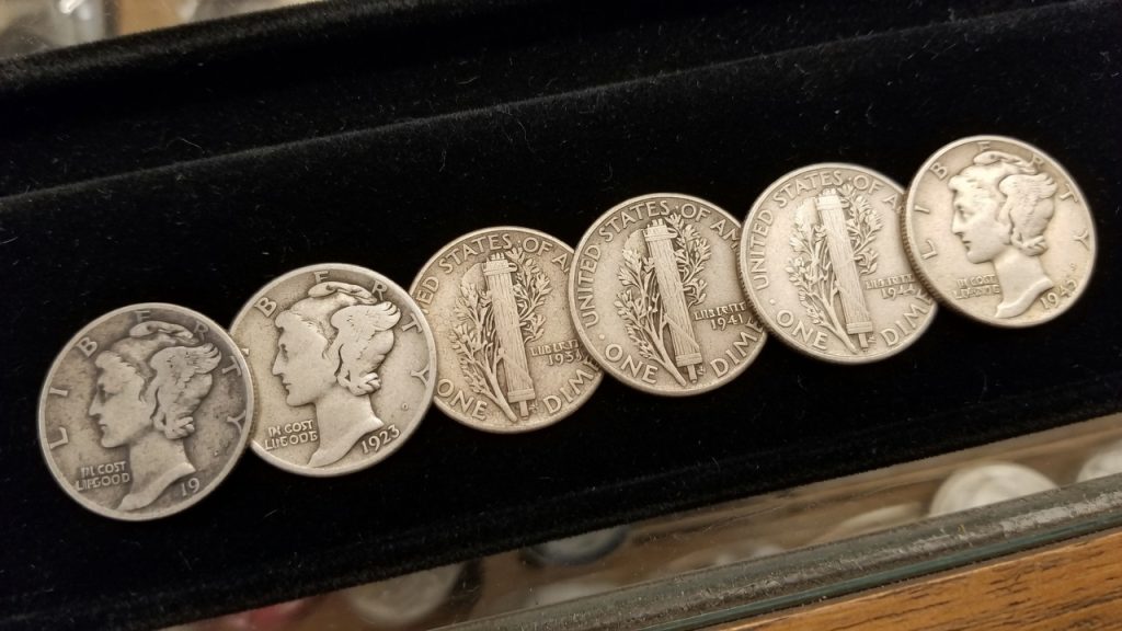 A row of Mercury dimes on black velvet showing more remaining design from left to right
