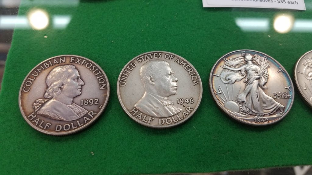An 1892 Columbian Exposition half, a 1946 Booker T. Washington half, and a Walking Liberty half