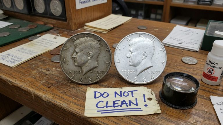 A toned 1964 Kennedy half next to a harshly cleaned one, tagged do not clean