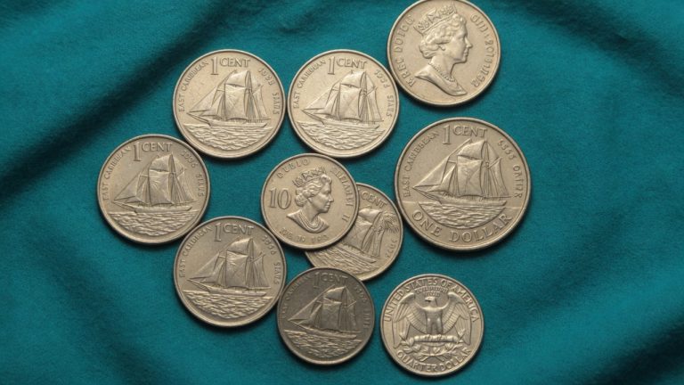 East Caribbean 1-cent sailing-ship coins and a Queen 10-cent piece next to a US quarter