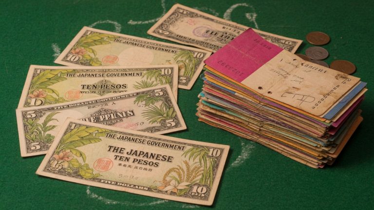 The Japanese Government occupation notes with tropical plants, pesos and dollars, beside a thick stack of paper
