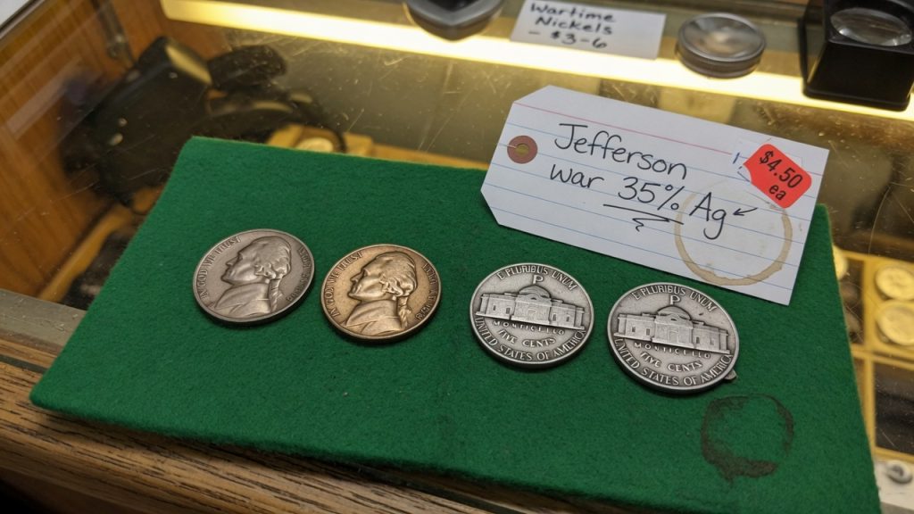 Jefferson nickels beside two 1943-P war nickels with a large P above Monticello