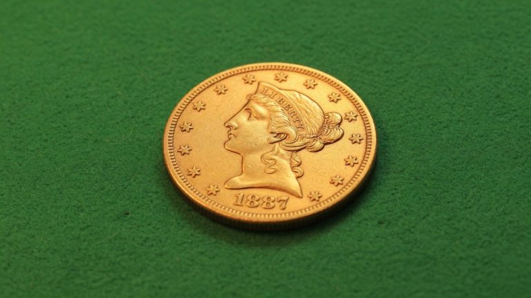 A Liberty Head five-dollar gold coin on green felt