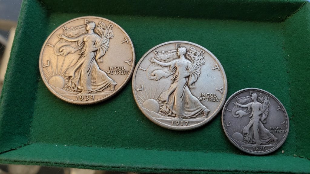 Walking Liberty half, Standing Liberty quarter, and Seated Liberty dime on a green felt tray