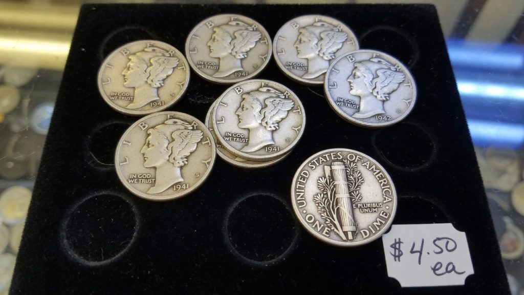 Worn Mercury dimes in a black tray