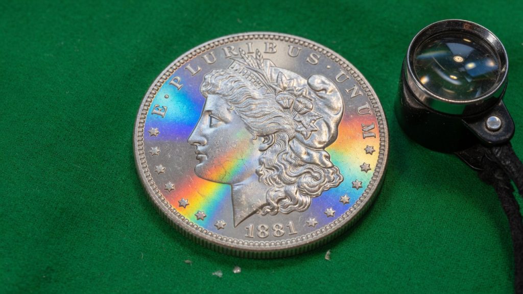 Close-up of a brilliant Morgan silver dollar on green felt with cartwheel luster