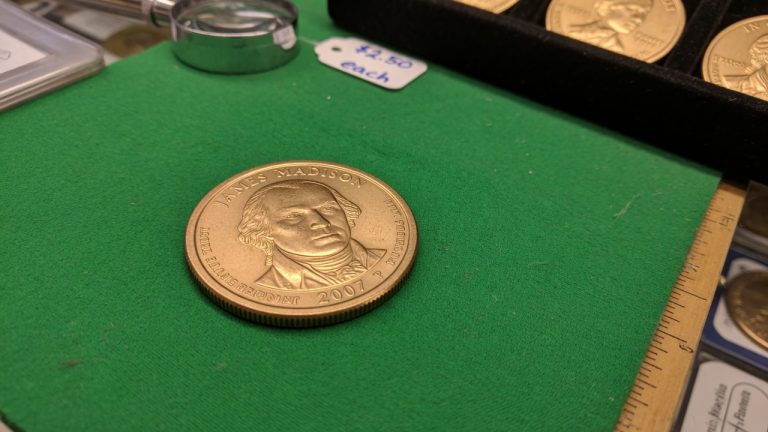 A United States Presidential dollar on green felt