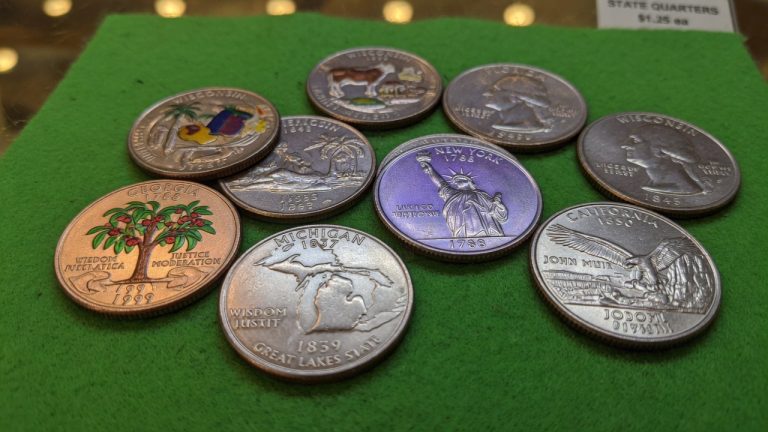 Several United States state quarters with different reverses on green felt