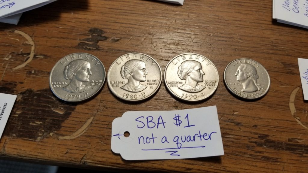 Susan B. Anthony dollars next to a Washington quarter