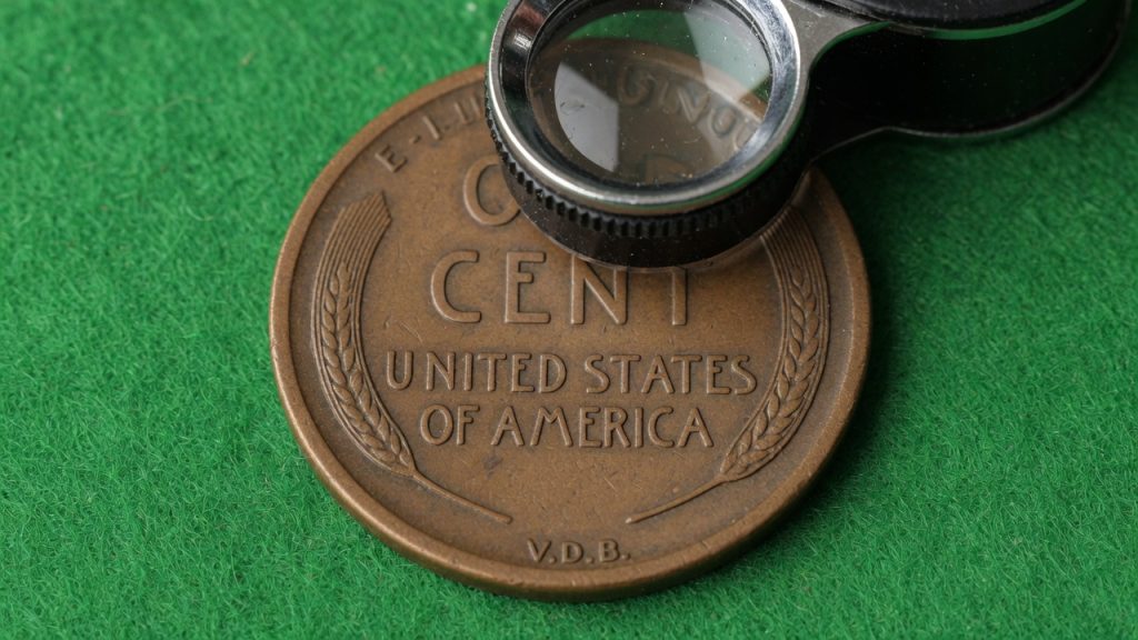 Lincoln wheat-cent reverse with tiny V.D.B. initials at the bottom rim and a loupe