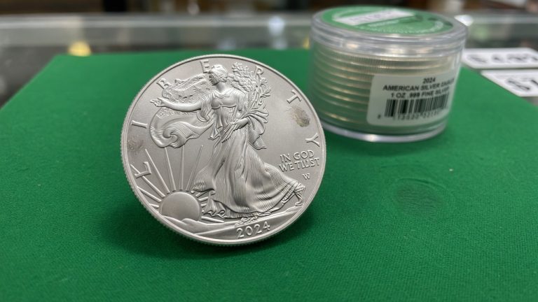 An American Silver Eagle with a West Point mint tube on green felt